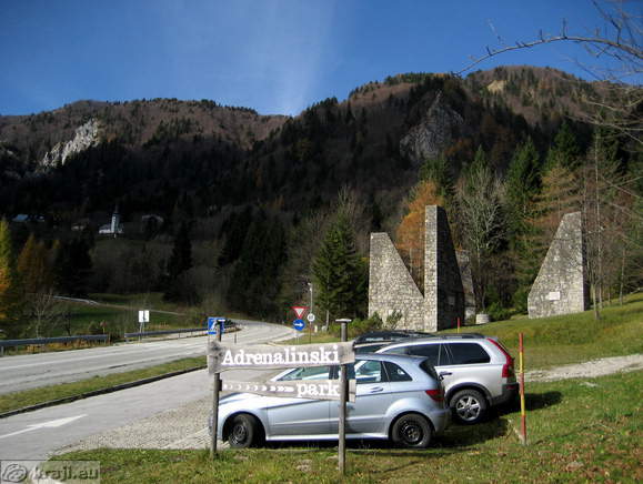 Parkirišče ob spomeniku, v ozadju cerkev sv. Ane na Ljubelju