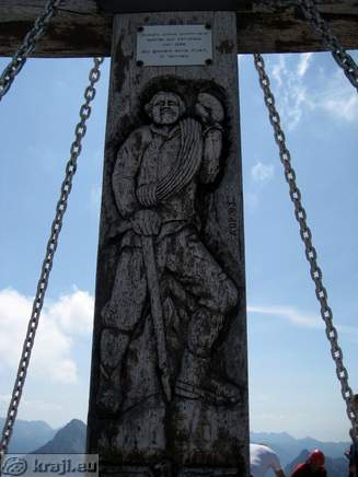 Figure on cross on Mangart summit Figure on cross on Mangart summit
