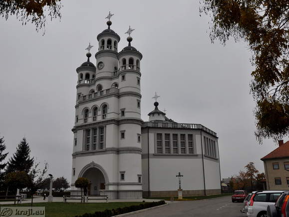 Cerkev Svete Trojice in manjši parkirišče ob njej